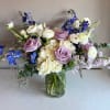 A stunning arrangement of delicate lavenders and whites lisianthus, roses, and ranunculus