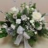 centerpiece filled with winter greens, white flowers and silver accents.  Long