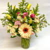 This bright arrangement features variety of roses, solidago, tulips, stock, wax flower