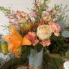 Fall arrangement or winter arrangement containing with vivid orange flower colors, tuba