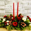 A lovely 2 Candle Mixed Winter Green Centerpiece with Pinecones, Red Roses
