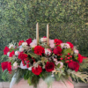 A Beautifully adorn centerpiece with silver ornaments and ribbons, red roses and