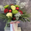 This festive bouquet features bright greens, reds and white arranged in a