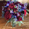 Bouquet filled with roses and specialty burgundy and purple flowers
