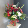 A beautiful, one-of-a-kind floral arrangement with fresh seasonal flowers in a vase.