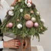 Handmade Christmas tree crafted adorned with dried flowers, cotton, and Christmas ornaments.The