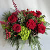 Red roses, green hydrangeas, blue thistle, seeded eucalyptus and hanging amaranths fill