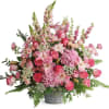 A stunning sympathy arrangement featuring elegant pink lilies, lush roses, hydrangeas, and