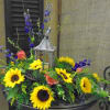 Small lantern designed with fresh cut flowers around it.

Sunflowers are seasonal and