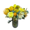 A radiant arrangement of yellow blooms featuring protea, calla lilies, ranunculus, cream