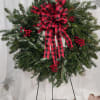 Lovely wreath made with mixed Christmas greenery, berries and a bow.