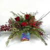 Seasonal design in a red and pink glass container, includes roses, pine