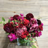 A fuller fall bouquet of romantic premium blooms in shades of red