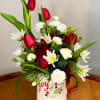 A festive and cheery winter mug arrangement with beautiful red tulips.