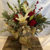 A Christmas classic...a gold cylinder filled with white lilies, red roses, red