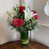Red and hot pink roses, white lily, and white alstromeria arranged with
