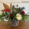 red roses blue thistle white spider and buttons arranged with magnolia and