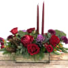 A rustic display of flowers curated in a wooden container holds the