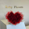 stunning heart-shaped arrangement of deep red roses, elegantly wrapped with sheer white