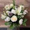 All white flower arrangement with Pinecones in a clear vase