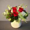 Beautiful red roses accented with white hydrangea and winter greens 