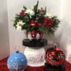 Assorted style glass Christmas ball candy dish with cut evergreens and fresh