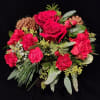 A beautiful Christmas arrangement in a red cube vase.