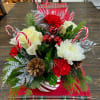 A beautiful candy cane vase filled with winter greens and fresh holiday