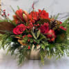 A beautiful centerpiece for the holidays filled with winter greens, berries, red