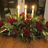 elegant centerpiece of rich red roses and fresh Christmas greens, artistically arranged