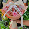 This cute wrap bouquet is made up of pink and brown roses