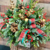 A country classic of assorted evergreens, plaid ribbon, cones and berries beautifully