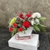 White Sleigh filled with mini carnation, chrysanthemums, roses, red berries, with cedar