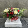 Red sleigh filled with alstroemeria, mini carnation, snap dragon, roses, blooming filler