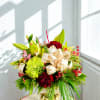 The arrangement features vibrant red carnations and distinctive lime green mums (also