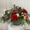 This festive arrangement is presented in a clear glass cylinder vase, holiday