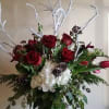 Red roses, white hydrangea and snowy branches with seasonal foliage. 