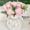An iridescent adorable vase filled with  giant pink peonies and a