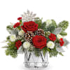 A festive blend of red roses, winter greens, and pinecones arranged in