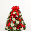 A stunning Christmas tree&ndash;shaped arrangement featuring red roses, white blooms, festive greenery