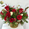 A radiant Christmas arrangement featuring lush red roses set in a shimmering