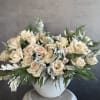 Quicksand roses meet lush Christmas greenery in a sophisticated arrangement full of