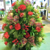 Mixture of Fresh Christmas greens, mini carnations, ornaments, berries and bows. About