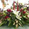 Beautiful and classic holiday centerpiece accented with fresh flowers, pine cones, ornaments