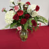 This timeless arrangement blends rich romance with crisp elegance. Lush red roses