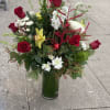 Spread holiday cheer, with this arrangement of roses, orchid cymbidium, mix fir