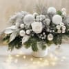 A luminous Christmas flower centerpiece in white and silver brings calm sparkle