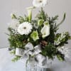 Winter greens and white florals in a metallic silver glass cube vase