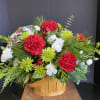 Holiday greenery, carnations and mums in a basket