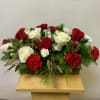 A Holiday Box Arrangement with Christmas Greens. Accented with Pinecones and a